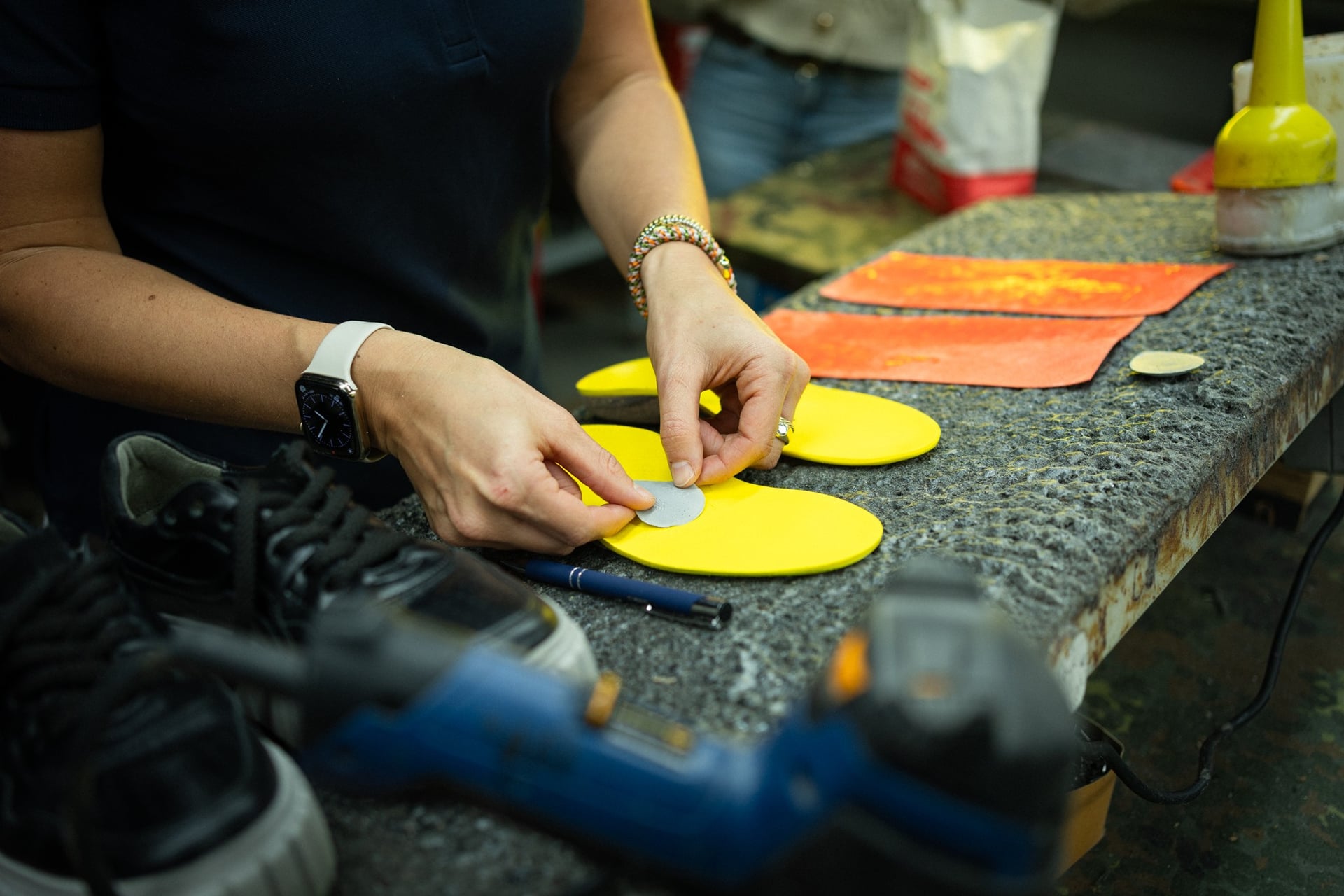 Hände schneiden gelbe Einlagenrohlinge in der Werkstatt der Jordan Orthopädieschuhtechnik